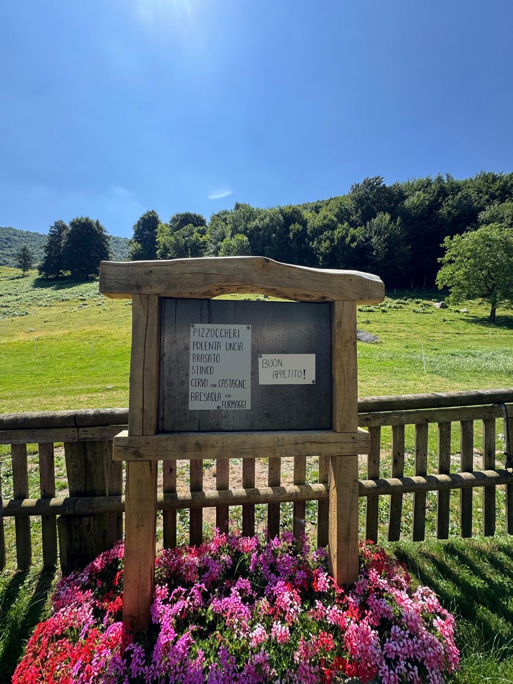 Cartello del menu dell’Alpe con vista sui prati