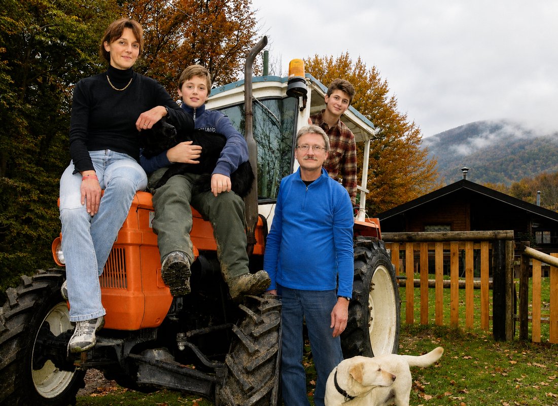 La famiglia sul trattore davanti allo chalet dell'Alpe